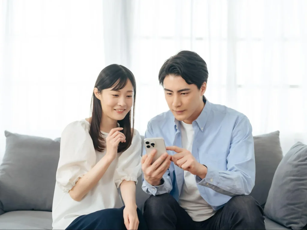 夫婦が、注文住宅のおしゃれな内装の施工事例をSNSやWEBサイトで情報を収集している様子